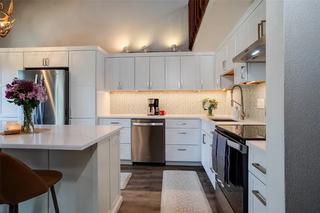 a kitchen with granite countertop a sink stove and refrigerator