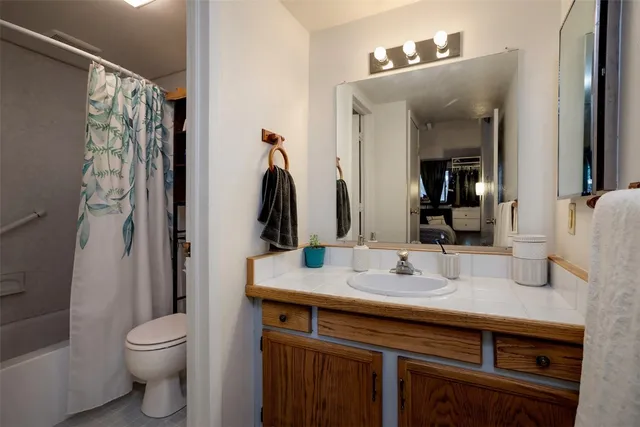 a bathroom with a granite countertop sink toilet and shower