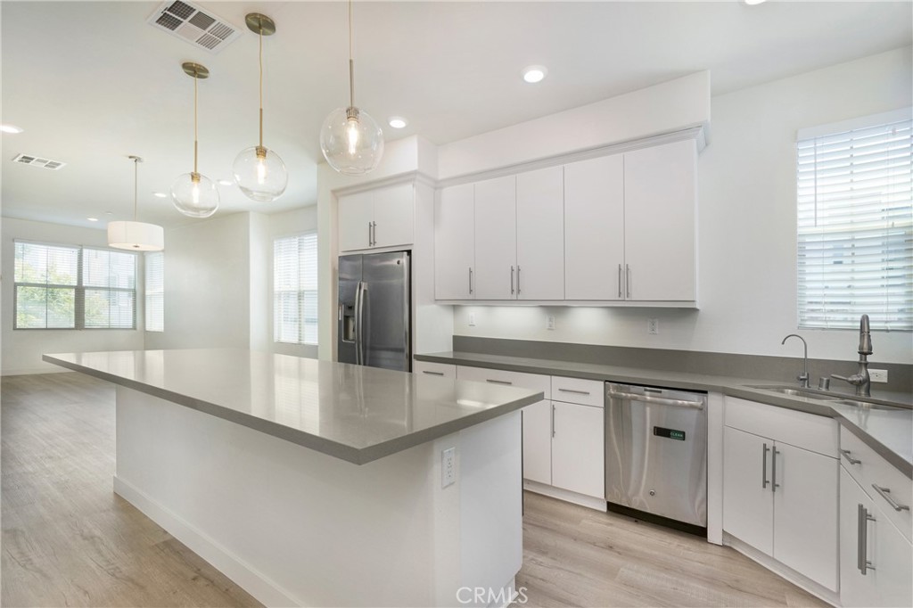 148 Acamar Irvine, CA 92618 - Photo 2 of 23 a large kitchen with granite countertop a sink a center island stainless steel appliances and a window