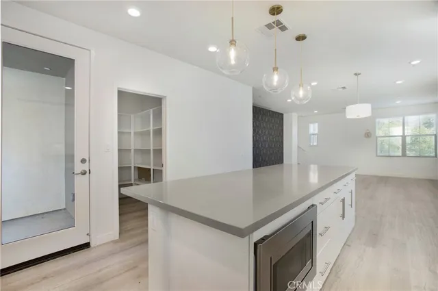 a large kitchen with granite countertop a large counter top stainless steel appliances and cabinets