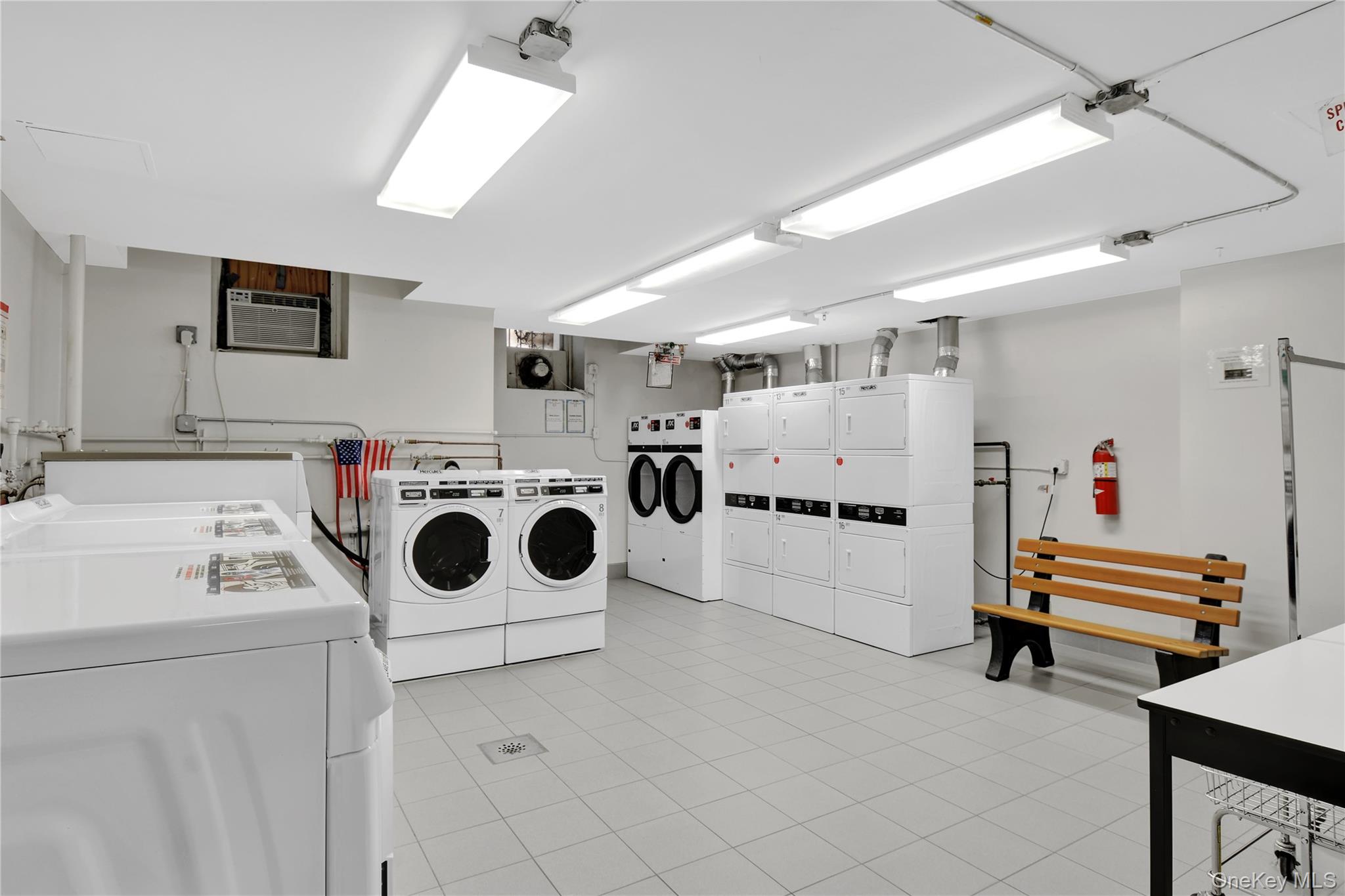 315 West 232nd Street, Unit 1F Bronx, NY 10463 - Photo 13 of 18 Shared laundry room with separate washer and dryer, light tile patterned flooring, and an AC wall unit