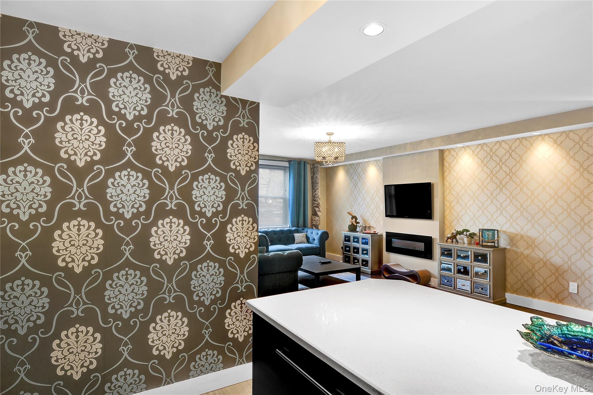 315 West 232nd Street, Unit 1F Bronx, NY 10463 - Photo 18 of 18 Kitchen featuring wallpapered walls, dark cabinetry, open floor plan, a chandelier, and hanging light fixtures