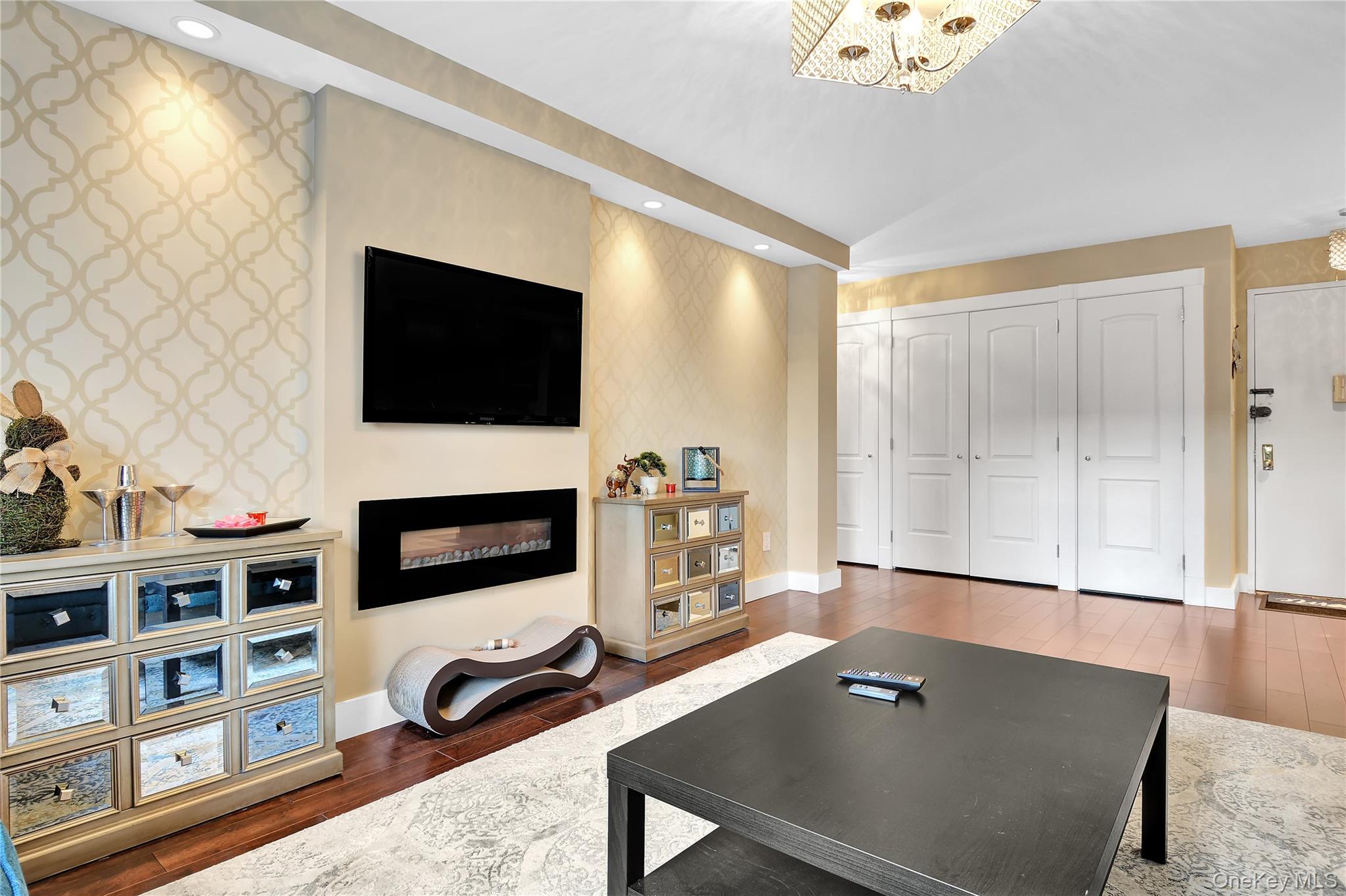 315 West 232nd Street, Unit 1F Bronx, NY 10463 - Photo 9 of 18 Living area featuring dark wood finished floors, a fireplace, wallpapered walls, recessed lighting, and an accent wall