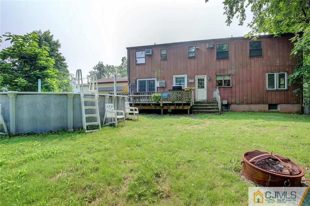 22 Cottrell Road Old Bridge, NJ 07747 - Photo 28 of 32 a view of a backyard with table and chairs with wooden fence