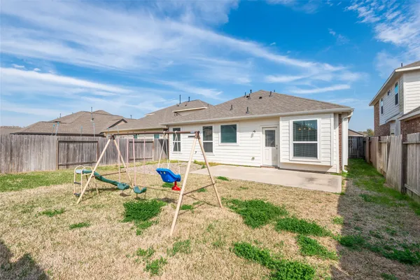 a view of a house with backyard and sitting area