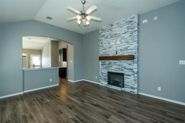 a view of empty room with wooden floor and fireplace