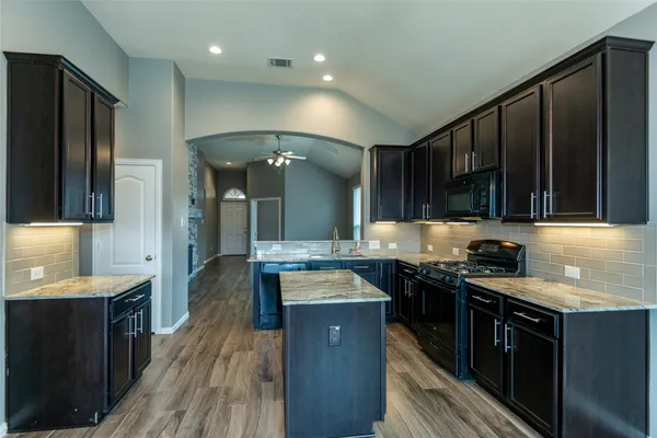 a kitchen with stainless steel appliances granite countertop wooden cabinets stove top oven and sink