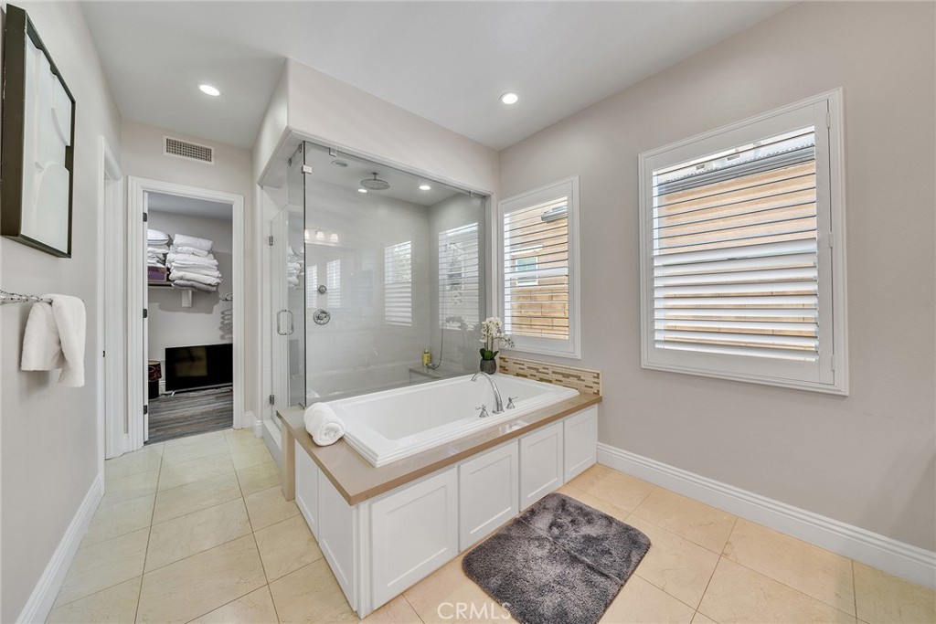 61 Windwalker Way Tustin, CA 92782 - Photo 29 of 62 a spacious bathroom with a tub a sink and a mirror