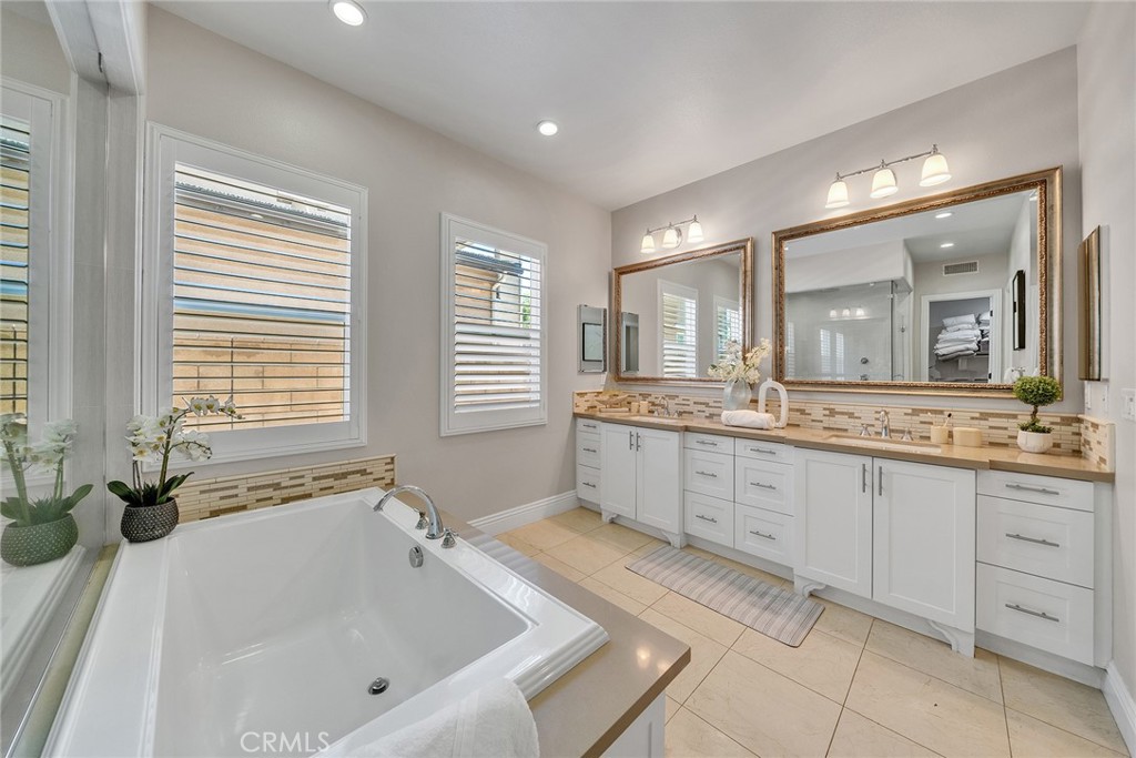 61 Windwalker Way Tustin, CA 92782 - Photo 30 of 62 a spacious bathroom with a tub sink and mirror