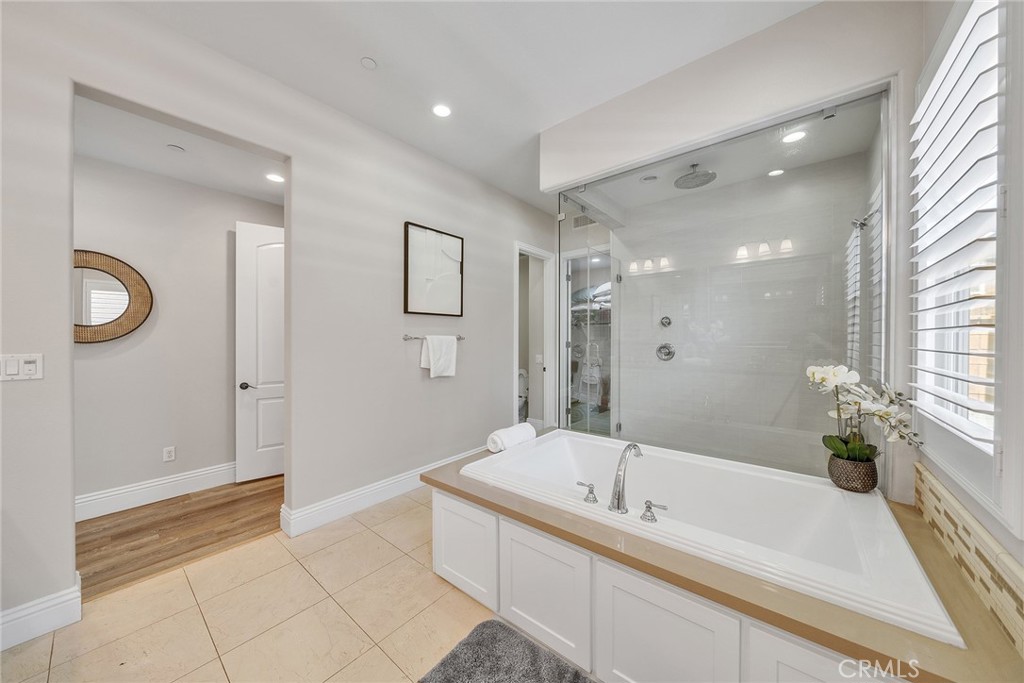 61 Windwalker Way Tustin, CA 92782 - Photo 31 of 62 a bathroom with a tub a sink and a large mirror