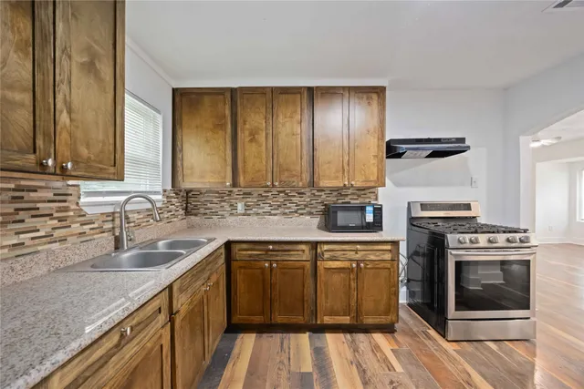 a kitchen with a sink stove and cabinets