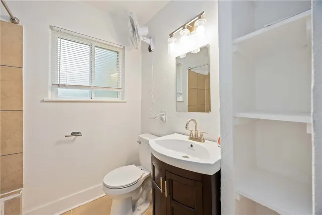 a bathroom with a sink toilet and a mirror