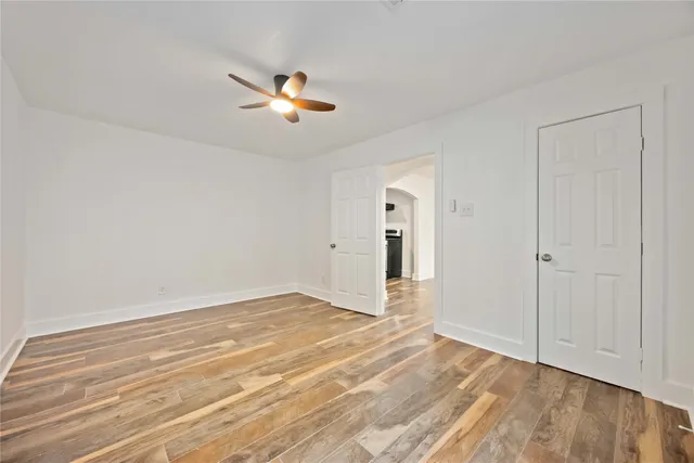 a view of a livingroom with wooden floor and a ceiling fan