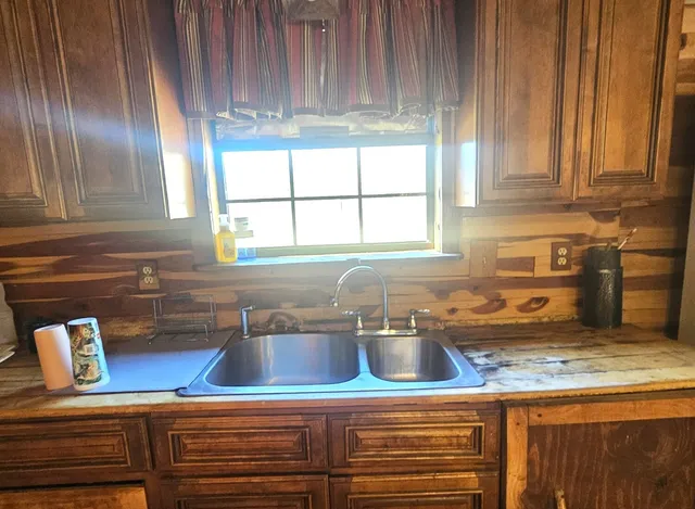 a kitchen with granite countertop stainless steel appliances wooden floor sink and cabinets