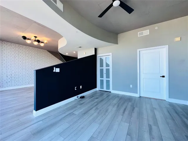 a view of an empty room with wooden floor