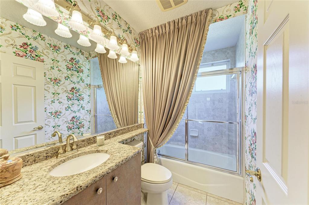 5060 Robinsong Road Sarasota, FL 34233 - Photo 34 of 42 a bathroom with a granite countertop sink toilet and shower
