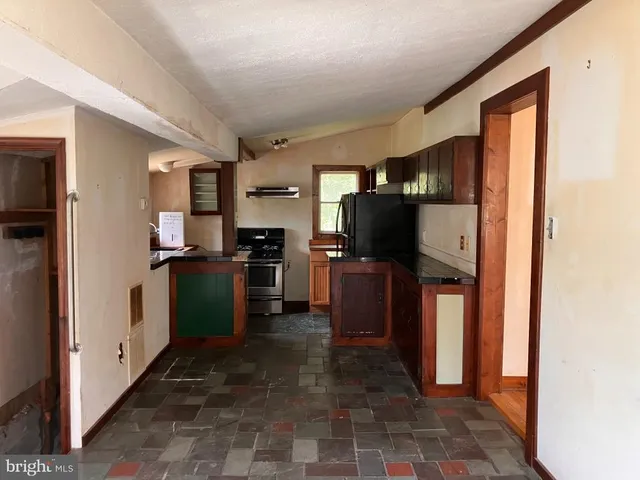 a kitchen with granite countertop a refrigerator and a sink