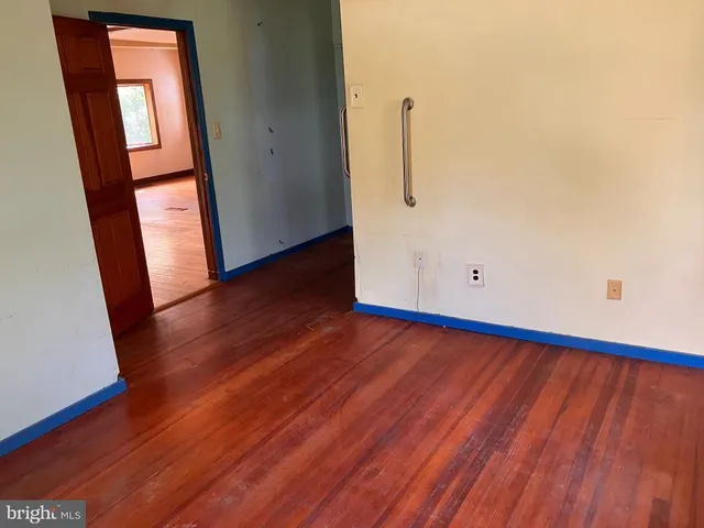an empty room with wooden floor and entrance