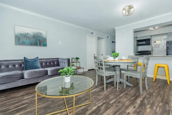 a living room with furniture a chandelier and a dining table