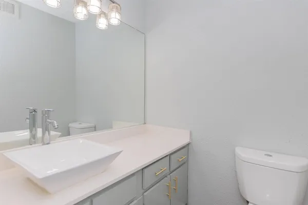 a bathroom with a sink a toilet and a mirror