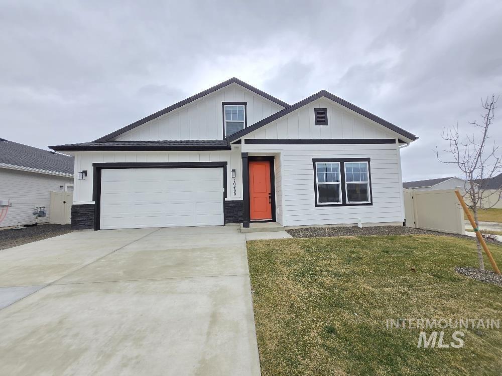 View of front of home featuring concrete driveway, board and batten siding, and stone siding