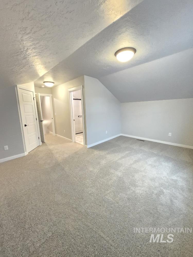 10400 Bellevue Ridge Street Nampa, ID 83687 - Photo 12 of 27 Bonus room with a textured ceiling, light colored carpet, and vaulted ceiling