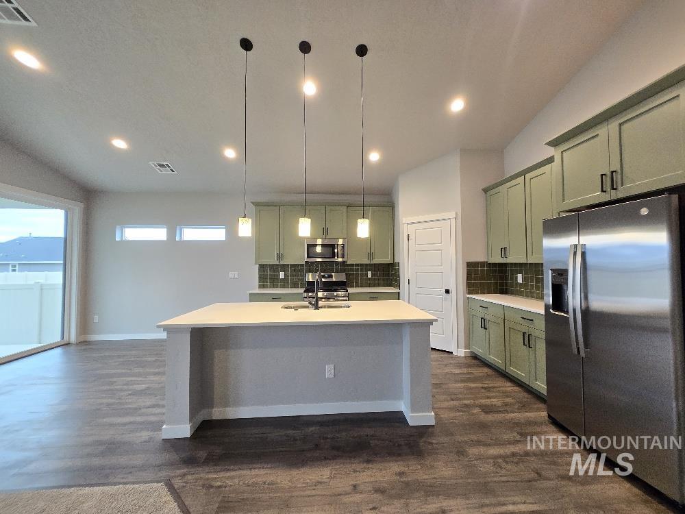 10400 Bellevue Ridge Street Nampa, ID 83687 - Photo 6 of 27 Kitchen with green cabinetry, stainless steel appliances, a center island with sink, pendant lighting, and recessed lighting
