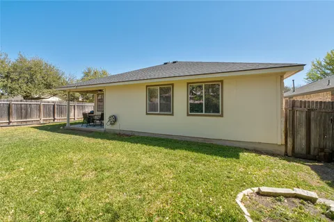 a backyard of a house with table and chairs