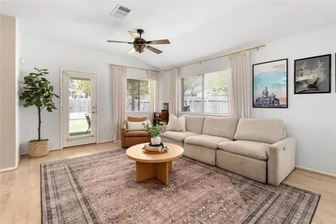 a living room with furniture a window and a potted plant