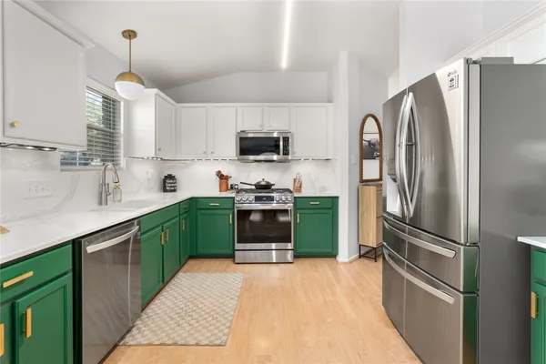 a kitchen with kitchen island a counter top space stainless steel appliances and cabinets