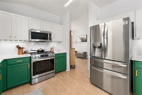 a kitchen with stainless steel appliances granite countertop a refrigerator microwave and stove top oven