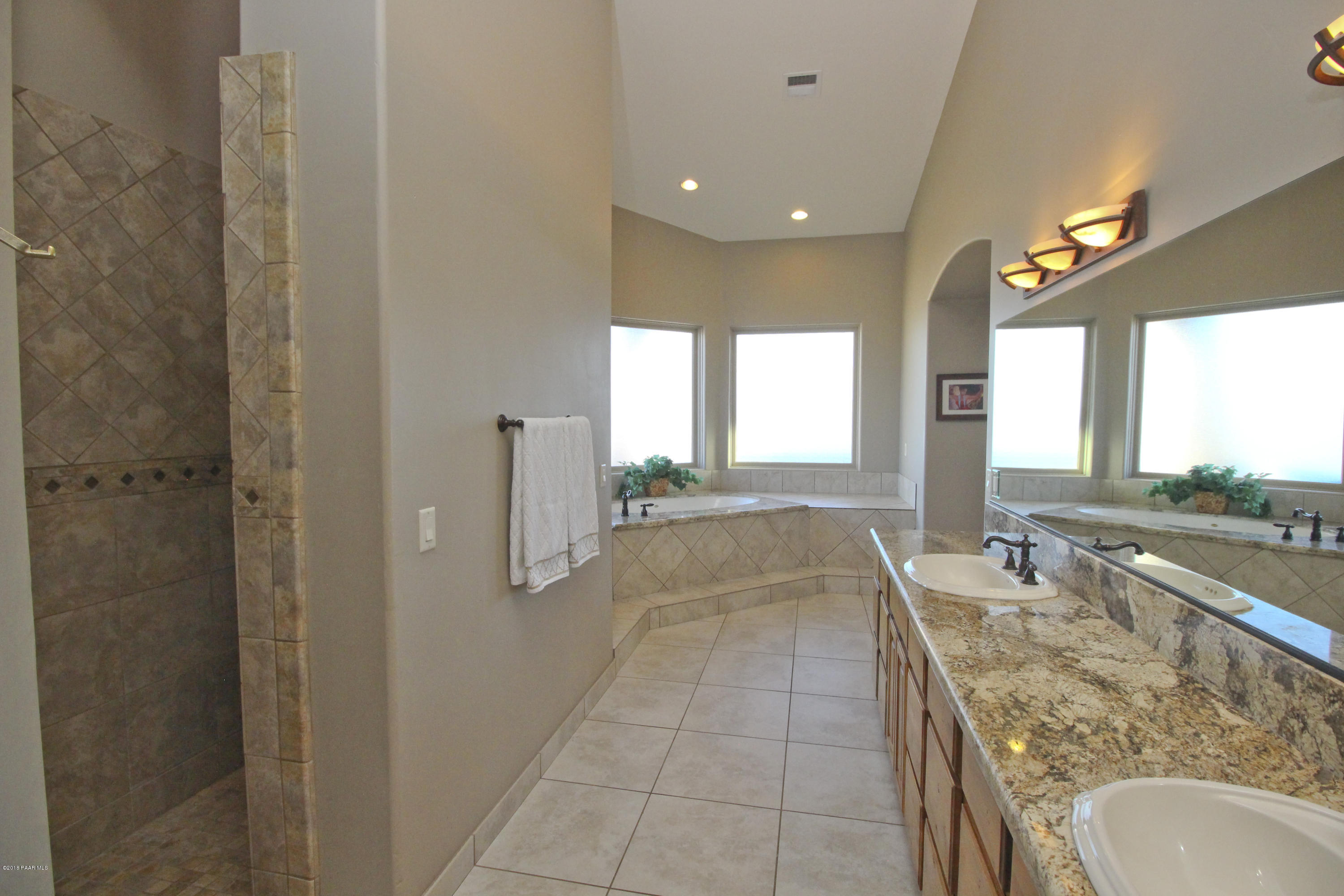 4800 West Mint Creek Road Prescott, AZ 86305 - Photo 16 of 62 a spacious bathroom with a granite countertop sink a mirror and shower