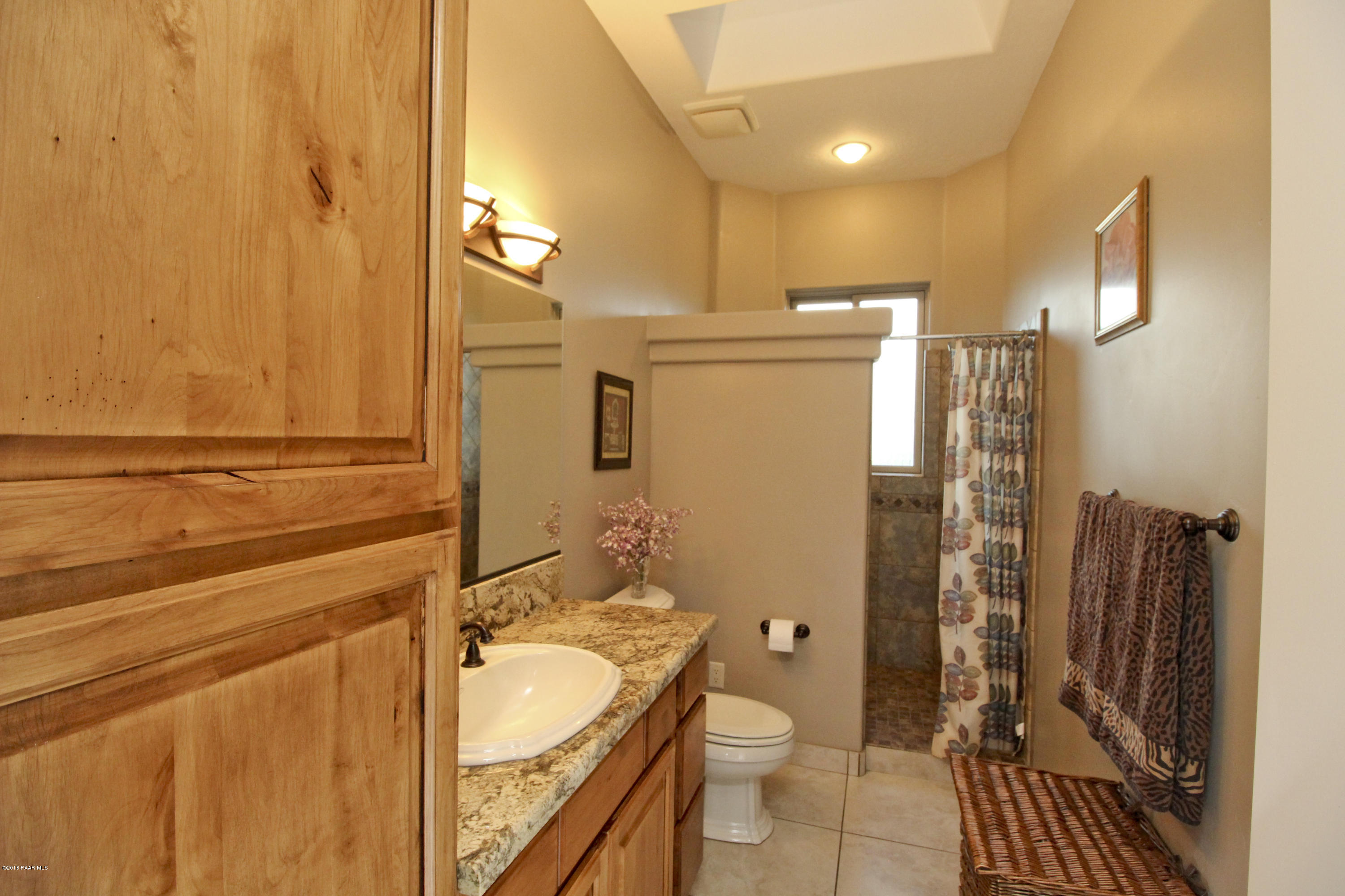 4800 West Mint Creek Road Prescott, AZ 86305 - Photo 20 of 62 a bathroom with a granite countertop sink toilet and shower