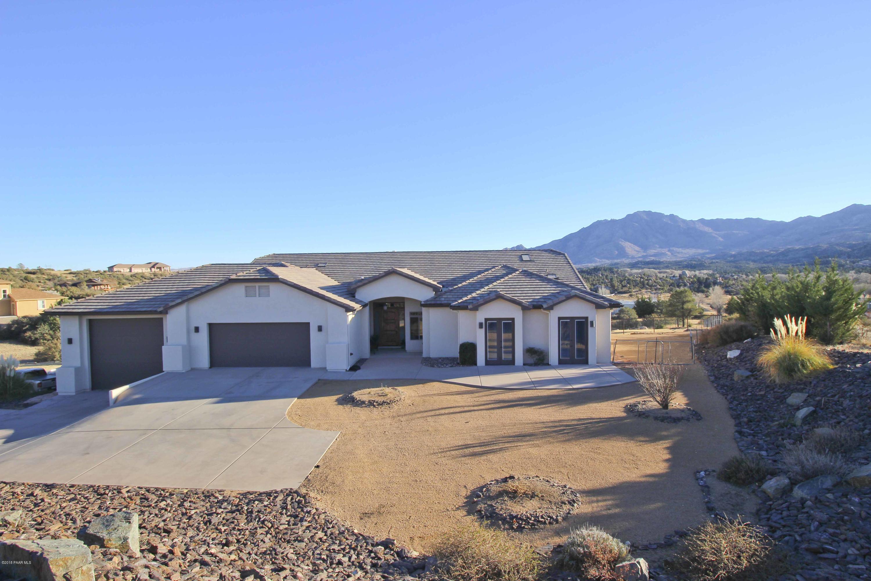 4800 West Mint Creek Road Prescott, AZ 86305 - Photo 46 of 62 a view of a white house with a yard and wooden fence