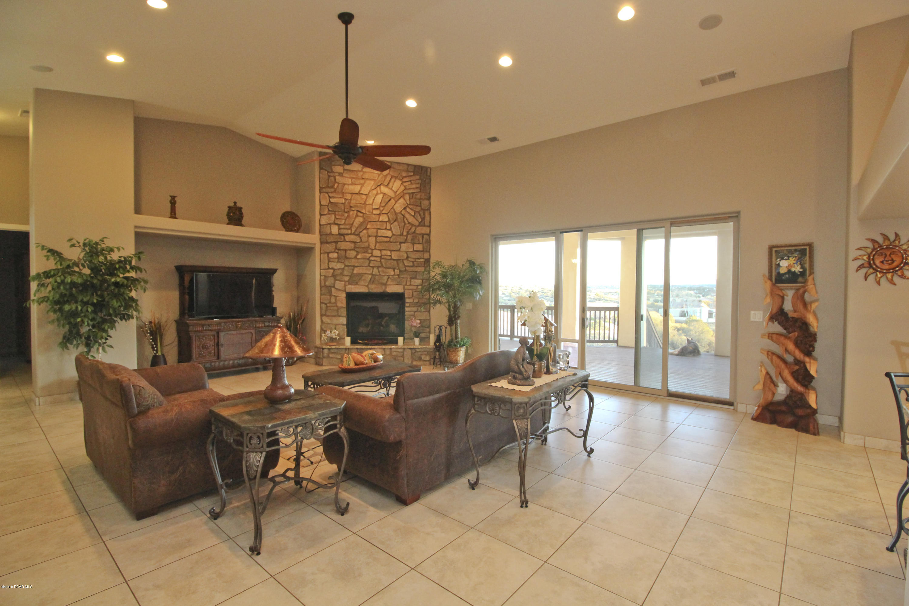 4800 West Mint Creek Road Prescott, AZ 86305 - Photo 7 of 62 a living room with furniture a fireplace and a floor to ceiling window