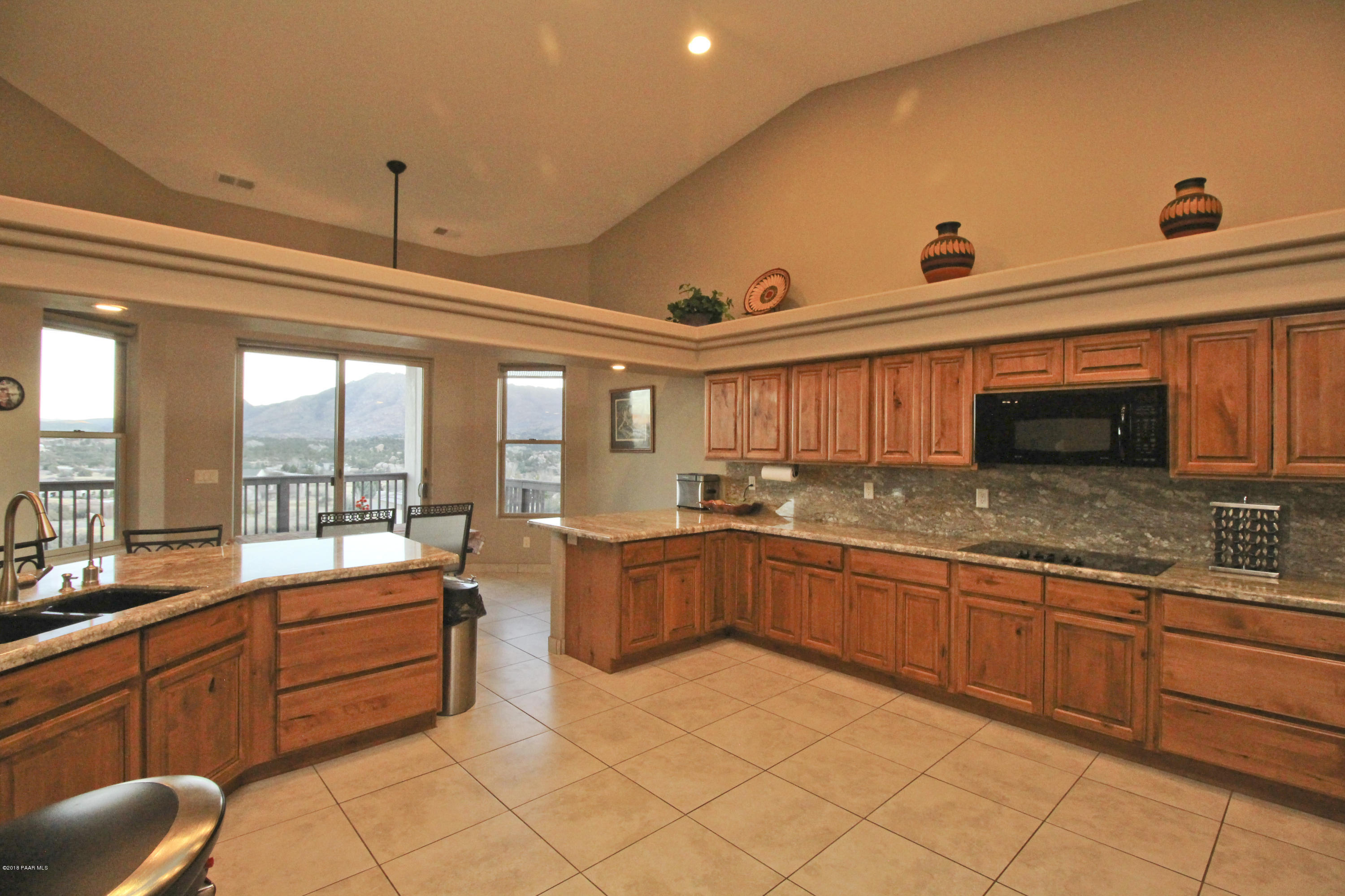 4800 West Mint Creek Road Prescott, AZ 86305 - Photo 9 of 62 a large kitchen with kitchen island granite countertop a large counter top couches and stainless steel appliances