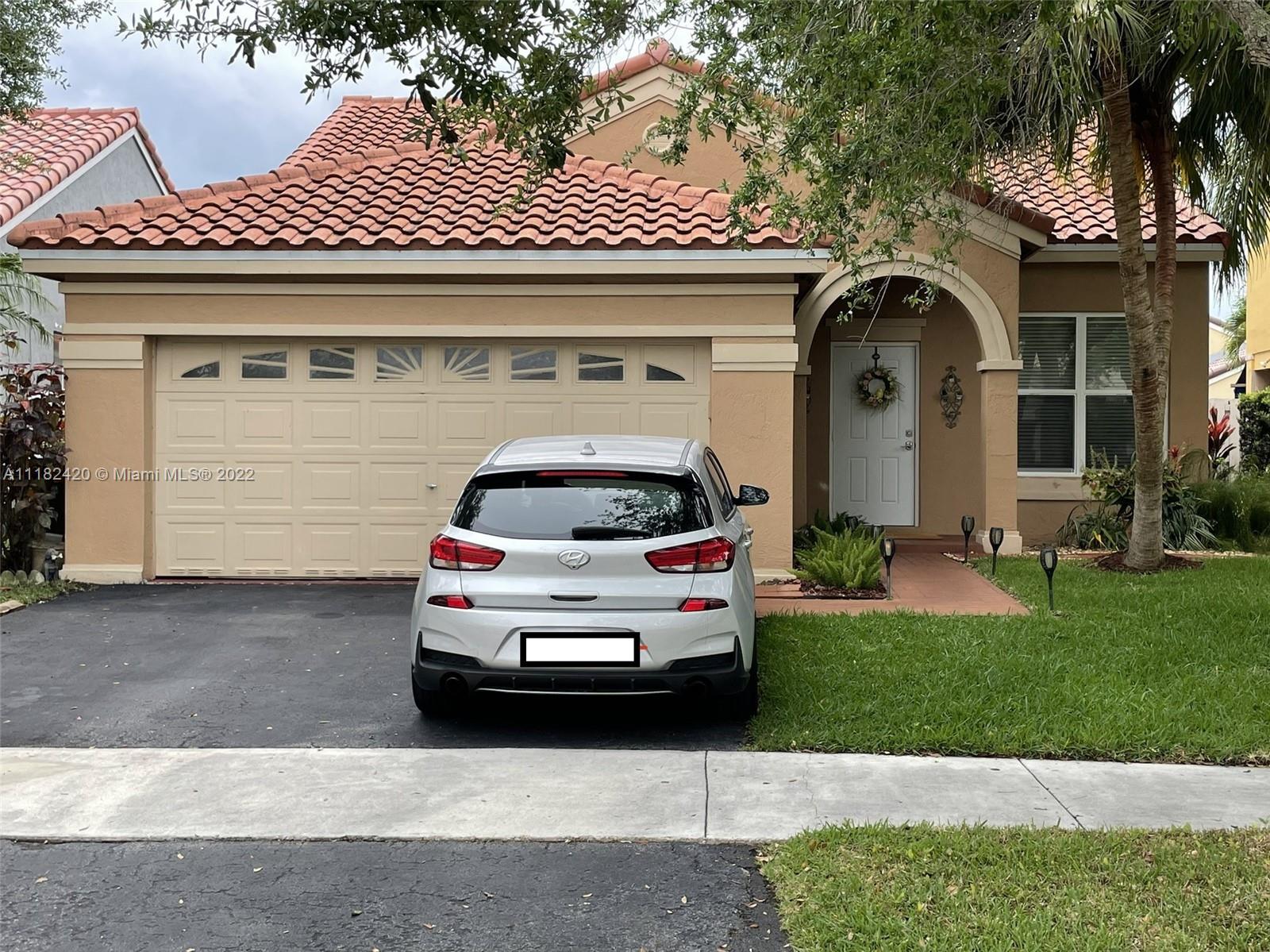 944 Falling Water Road Weston, FL 33326 - Photo 1 of 37 a car parked in front of white house
