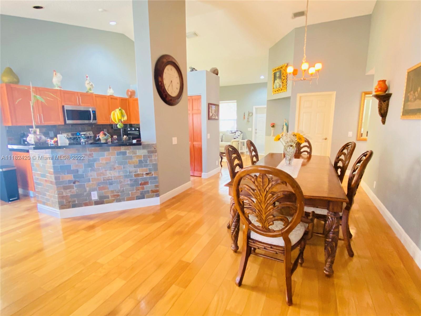 944 Falling Water Road Weston, FL 33326 - Photo 13 of 37 a view of a dining room with furniture and a chandelier