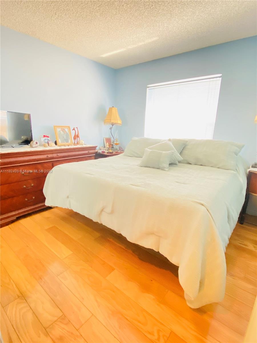 944 Falling Water Road Weston, FL 33326 - Photo 16 of 37 a bedroom with a bed and a painting on the wall