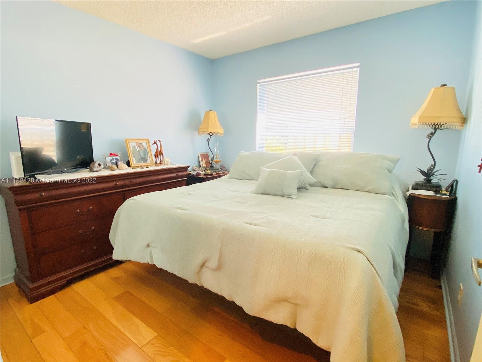 944 Falling Water Road Weston, FL 33326 - Photo 17 of 37 a bedroom with a bed and a potted plant