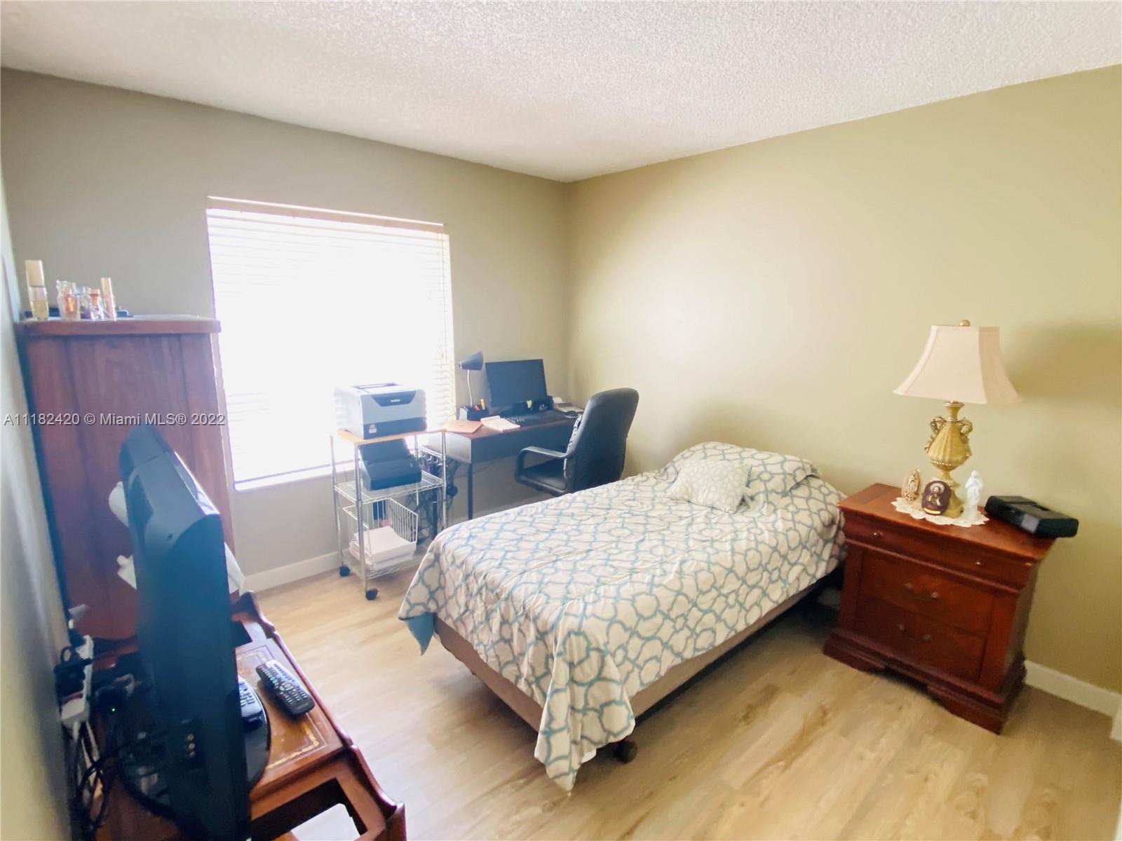 944 Falling Water Road Weston, FL 33326 - Photo 19 of 37 a bed room with a bed window and a chair