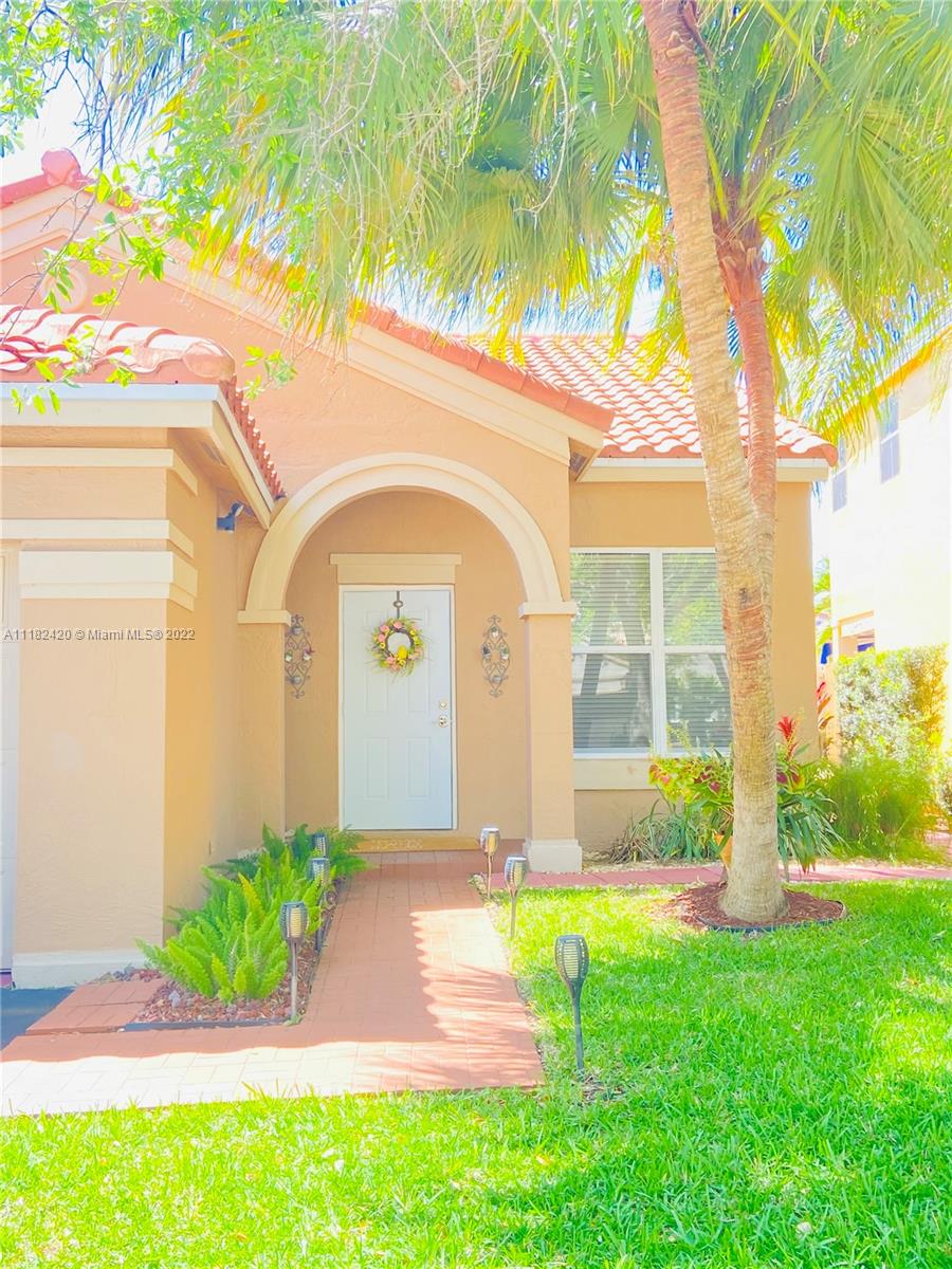 944 Falling Water Road Weston, FL 33326 - Photo 2 of 37 a front view of a house with garden