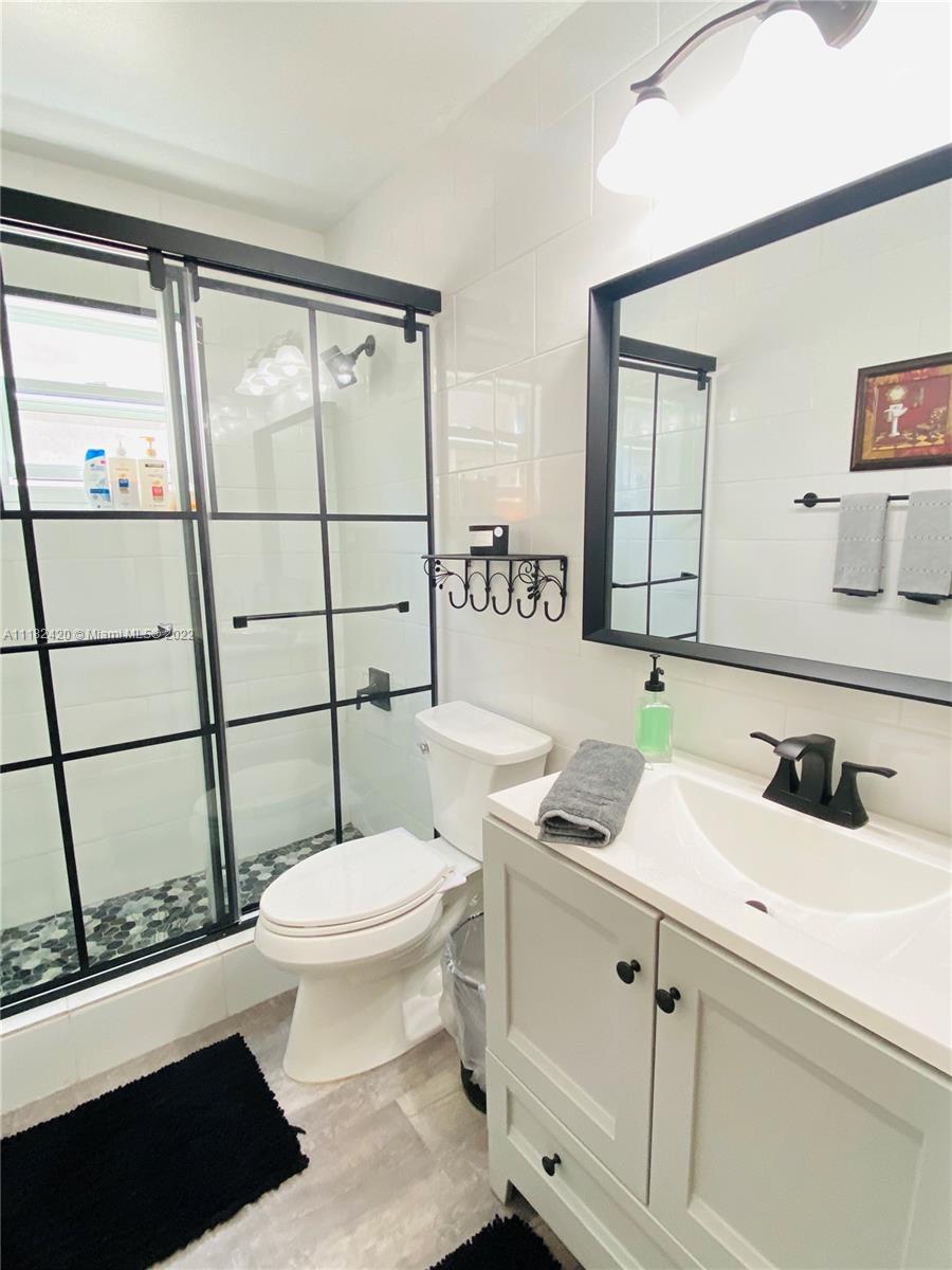 944 Falling Water Road Weston, FL 33326 - Photo 22 of 37 a bathroom with a sink a toilet a mirror and shower