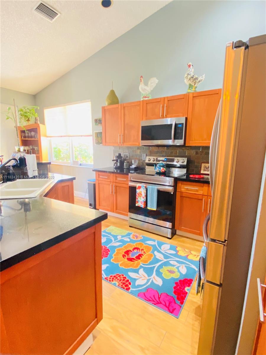 944 Falling Water Road Weston, FL 33326 - Photo 6 of 37 a kitchen with stainless steel appliances granite countertop a sink stove and refrigerator
