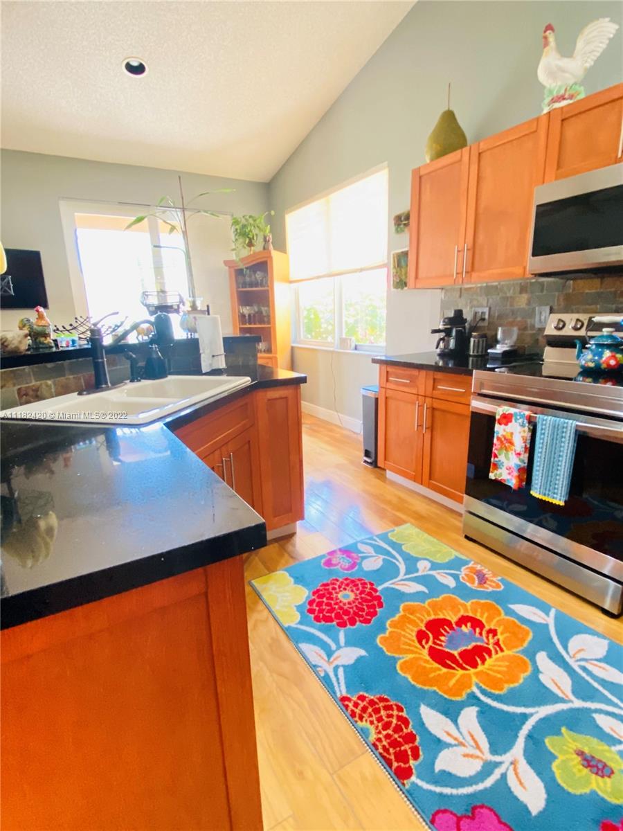 944 Falling Water Road Weston, FL 33326 - Photo 8 of 37 a kitchen with stainless steel appliances granite countertop sink dishwasher and a flat screen tv