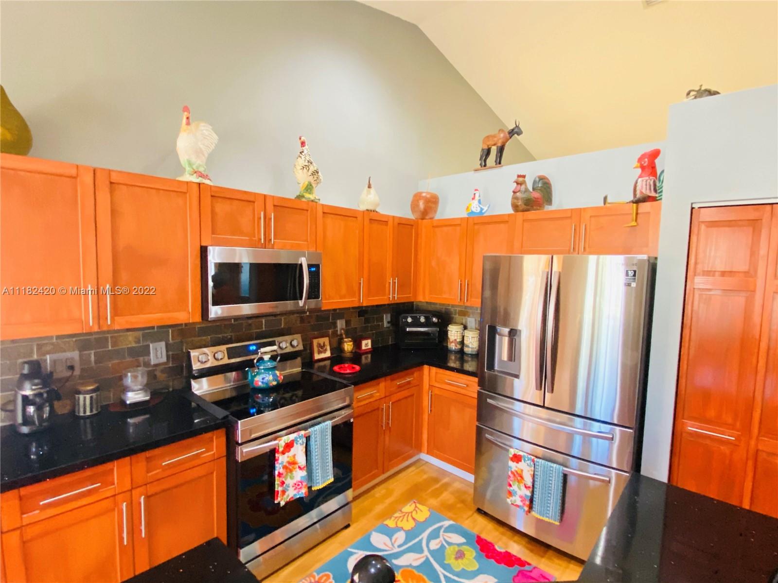 944 Falling Water Road Weston, FL 33326 - Photo 9 of 37 a kitchen with stainless steel appliances a refrigerator and a stove top oven