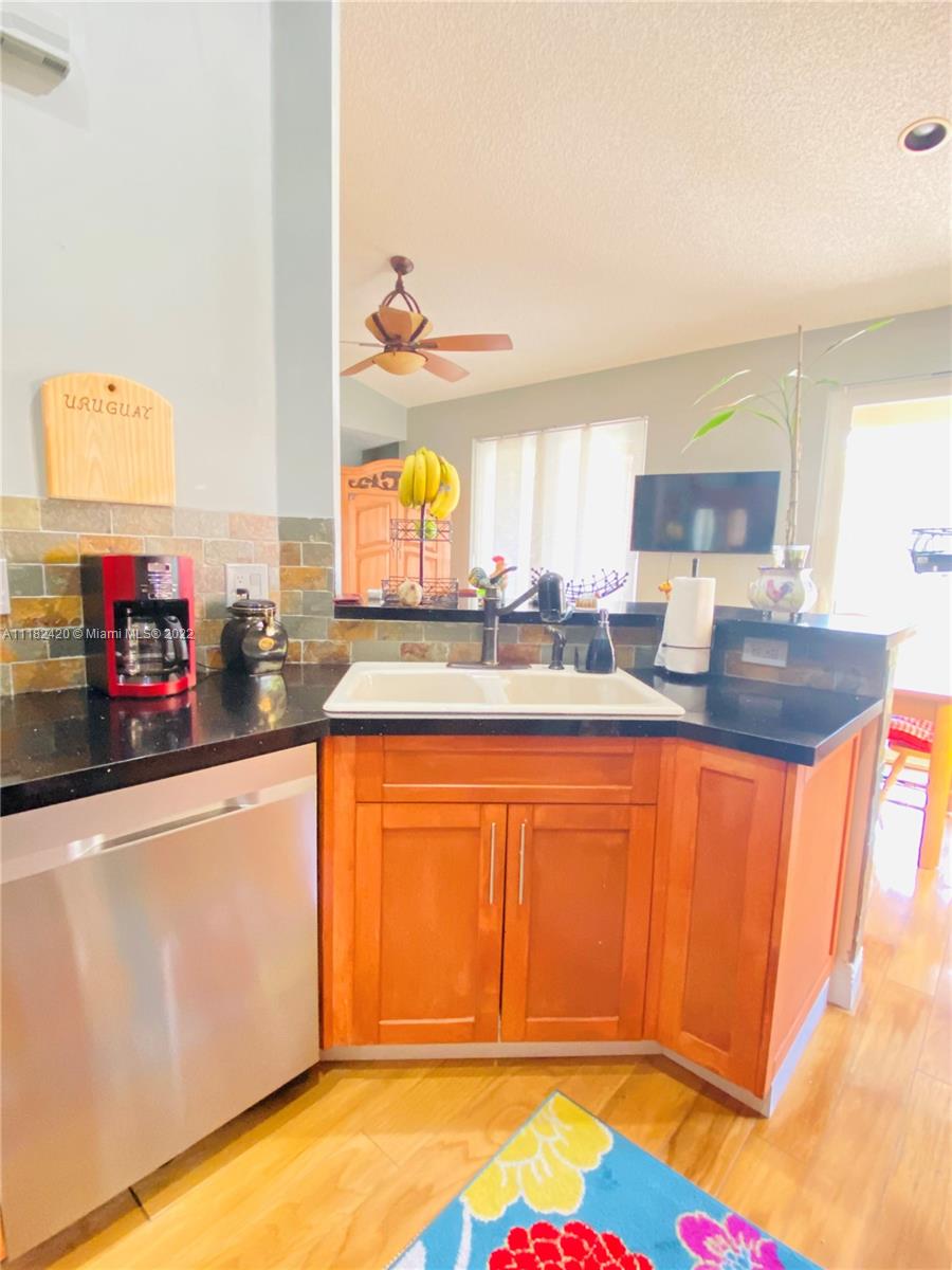 944 Falling Water Road Weston, FL 33326 - Photo 10 of 37 a kitchen with stainless steel appliances granite countertop a sink and cabinets