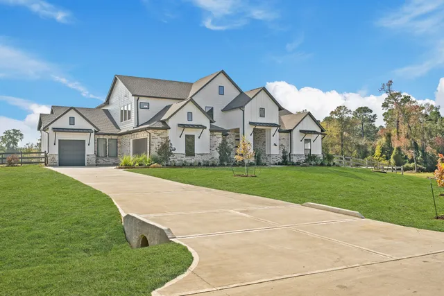 a large kitchen with kitchen island a stove a sink a refrigerator and white cabinets with wooden floor