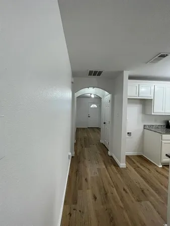 a view of a kitchen with wooden floor and a sink