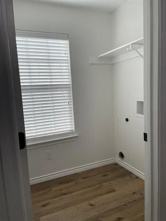 a view of a small space with wooden floor and a window